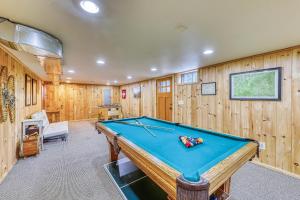 a pool table in a room with wooden walls at Eaglet Log Home in Franconia