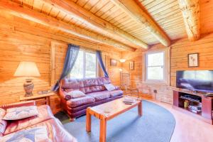 a living room with a leather couch and a tv at Twin View Log Home in Carroll