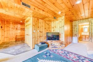 a living room with wooden walls and a television at Franconia Range View in Franconia
