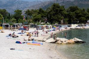 a group of people on a beach near the water at Apartments Magdalena in Stobreč