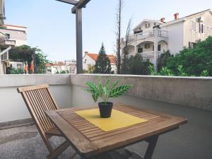 une table et une plante en pot sur un balcon dans l'établissement Apartment LIM, à Budva