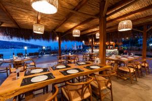 a restaurant with tables and chairs and a view of the ocean at Hotel Vita Bella Resort & Spa in Gundogan
