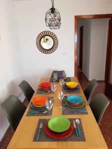 una mesa de madera con platos y copas de vino. en Fantástico apartamento cerca de la playa en Benicàssim