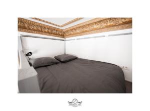 1 dormitorio con cama negra y techo dorado en L'Impérial Appart Hotel Poitiers, en Poitiers