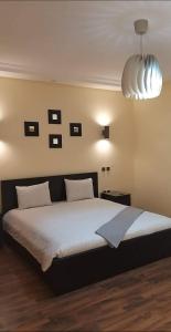a bedroom with a large bed and a large light fixture at Magnifique Villa a Savannah Beach in Sidi Rahal +21 photos