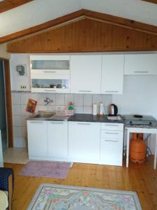 a kitchen with white cabinets and a wooden floor at Apartments Aida in Bihać