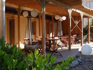 a wooden deck with tables and chairs on it at Merveilles88 in Rupt-sur-Moselle
