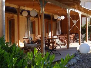 a wooden deck with tables and chairs on it at LE Relais des Anges in Rupt-sur-Moselle