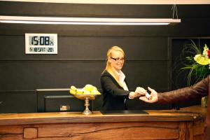 a woman standing at a counter shaking hands at Wildeshauser Hof in Wildeshausen