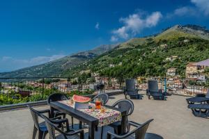a table and chairs on a balcony with a mountain at Il Pozzo Incantato in Vico Equense