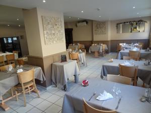 una sala da pranzo con tavoli, sedie e cercatore di tavoli di LE Relais des Anges a Rupt-sur-Moselle