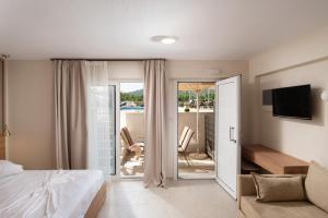 a bedroom with a bed and a view of a balcony at Astra Sarti Luxury Suites in Sarti