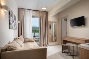 ein Wohnzimmer mit Couch und großem Fenster in der Unterkunft Astra Sarti Luxury Suites in Sarti