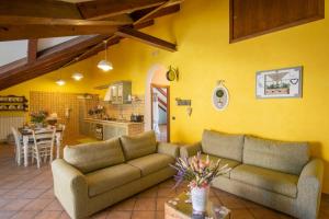 a living room with two couches and a kitchen at Mansarda Ciaciano in Bomerano