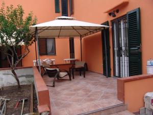 a patio with an umbrella and a table at Le Ciel d'Orphèe in Pisa