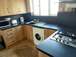 a kitchen with a stove and a washing machine at Rowe Gardens - Self Catering - Guesthouse Style - Comfortable Twin or Double Rooms - Quiet Residential Area in Workington