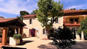 锡富尔勒普拉日Domaine de La Coudouliere, Vue Mer, Plage, Piscine et Parc的一栋房子前面有一棵树
