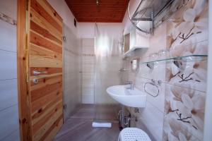 a white bathroom with a sink and a toilet at Turistična kmetija Čerček in Solčava