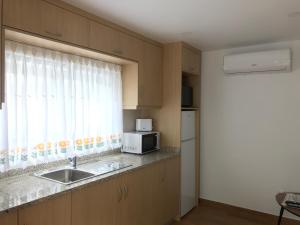 a kitchen with a sink and a microwave at Casa Dos Cabecinhos in Paradamonte