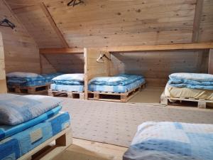 a room with four beds in a room with wooden ceilings at Planinarski dom "Tornik" Zlatibor in Ribnica