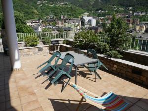 patio con mesa y sillas en el balcón en Xalet Marsal-Vacances Pirinenca, en Encamp