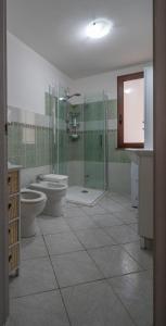 a bathroom with two toilets and a glass shower at Appartamento Belvedere Sassos in Tresnuraghes