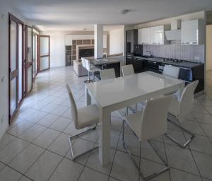 a kitchen and dining room with a white table and chairs at Appartamento Belvedere Sassos in Tresnuraghes