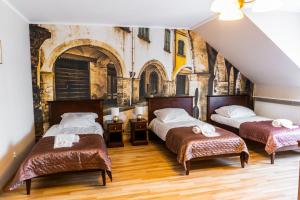 two beds in a room with a wall mural at Dworek Helena in Biała Podlaska