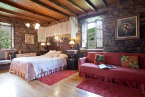 a bedroom with a bed and a couch and windows at Casa Ponce in Posada de Rengos