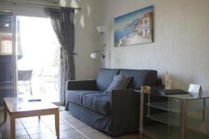 a living room with a blue couch and a glass table at Family Paradise- luxury combined with home comfort in Paphos City