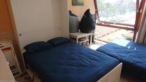 a bedroom with two beds and a large window at Studio Algarve in Middelkerke