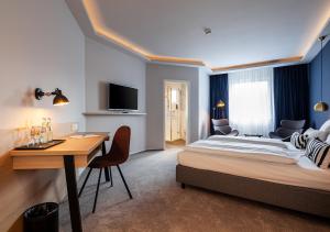 een hotelkamer met een bed, een tafel en een bureau bij Hotel Wittorf in Neumünster