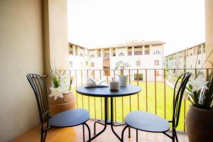 a small table and chairs on a balcony with a window at InnPisaRentals - Pisa Books & Tower Apartment in Pisa