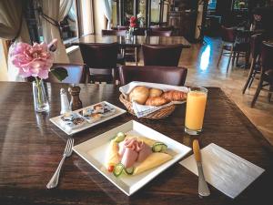 a table with two plates of food and a glass of orange juice at Restaurant Pansion Wien in Čierny Brod