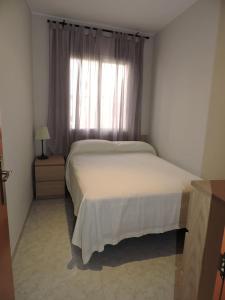 a bedroom with a white bed and a window at Carrer Sant Pere Pescador 20 in Blanes +7 photos