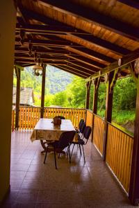 una mesa y sillas en un porche con vistas en Pensiunea La Cernat, en Şugag