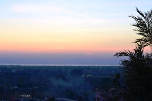 パラービタにあるMasseria Nuovaの前景の煙を伴う街の夕日