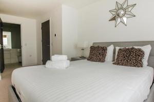 a bedroom with a large white bed with leopard pillows at Orion Marina Sea View - Parking - by Brighton Holiday Lets in Brighton & Hove