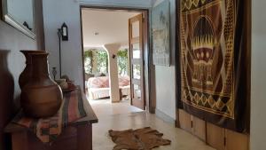 a living room with a vase on the floor and a hallway at Gately Inn Entebbe in Entebbe