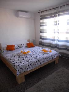 een slaapkamer met een bed met oranje kussens en een raam bij Amalia Belvedere in Rijeka