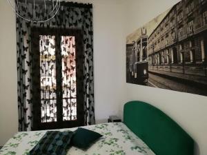 una camera da letto con un letto verde e una finestra di Casa Bumbunin, vicino al centro e al Politecnico a Torino