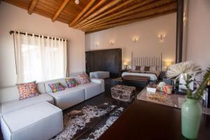 - un salon avec un canapé et un lit dans l'établissement Tocuyeros Boutique Hotel, à Cusco