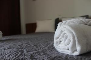 a roll of white towels sitting on a bed at Eurosun Hotels Loulé in Loulé