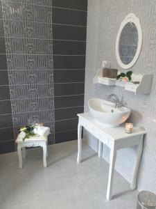 ein Badezimmer mit einem weißen Waschbecken und einem Spiegel in der Unterkunft Monato in Poprad
