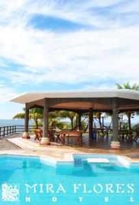 een zwembad met een prieel naast de oceaan bij Hotel Miraflores in El Cuco