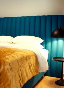 a bedroom with a blue wall with a bed and a table at Athens Blossom House under Acropolis with private entrance in Athens