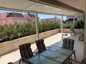 een patio met een tafel, 2 stoelen en een parasol bij Apartment Relax whit big terrace 170m2 Near the Beach in Split