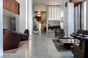 a living room with leather couches and a table at Hotel Bellevue in Rimini