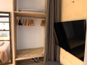 Habitación con cama, TV y armario. en Lovely studio Le Marais, en París