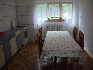 a kitchen with a table and chairs and a table and a window at Pensiunea Mir in Bran